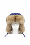 A blue leather aviator-style trapper hat with a large tan fur trim and ear flaps, displayed on a white mannequin head against a white background.