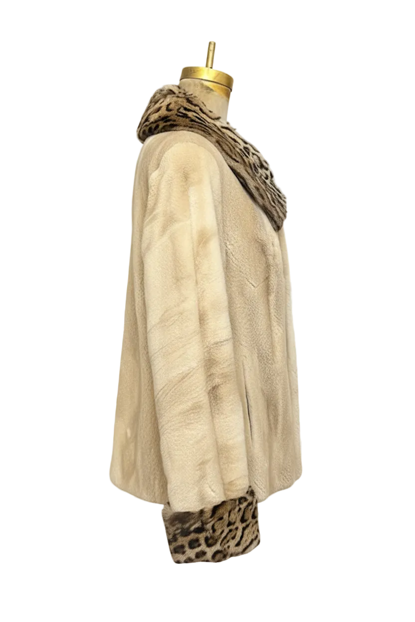 A cream-colored fur coat displayed on a mannequin torso, featuring leopard-print trim at the collar and hem, set against a transparent checkered background.